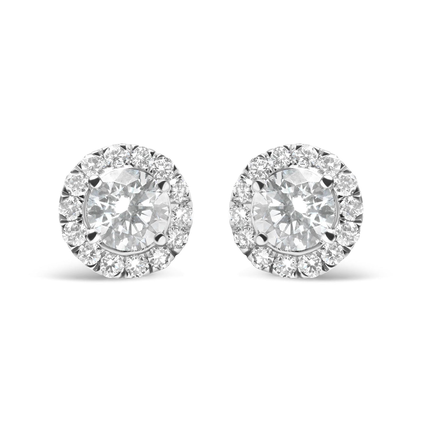 Front view of a pair of white metal stud earrings each featuring a large round white gemstone surrounded by a halo of smaller round white gemstones in prong settings.