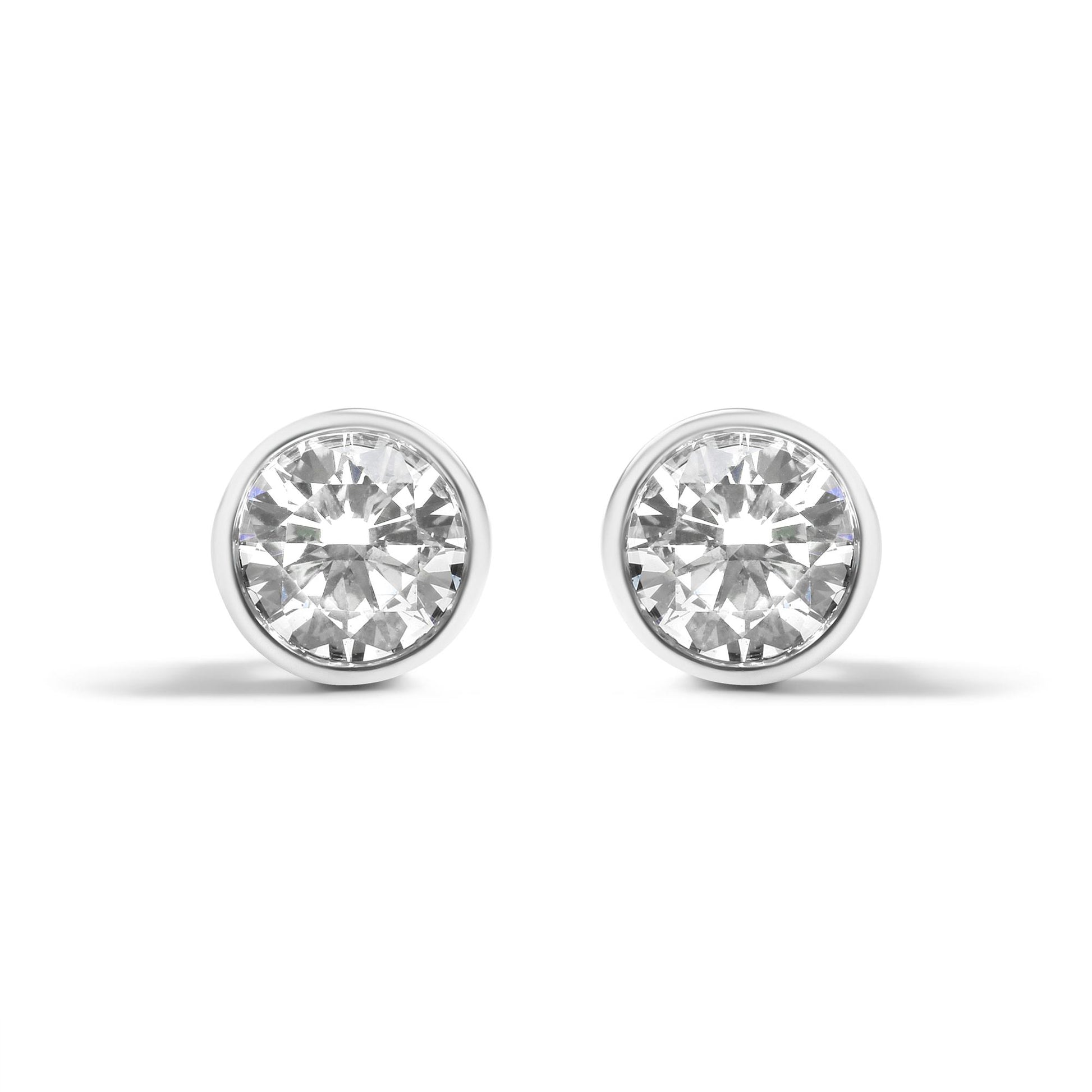 Front view of a pair of white metal round-shaped bezel set earrings with white gemstones.