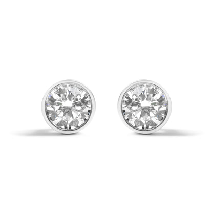Front view of a pair of white metal round-shaped bezel set earrings with white gemstones.