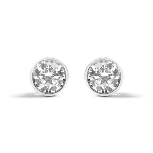 Front view of a pair of white metal round-shaped bezel set earrings with white gemstones.
