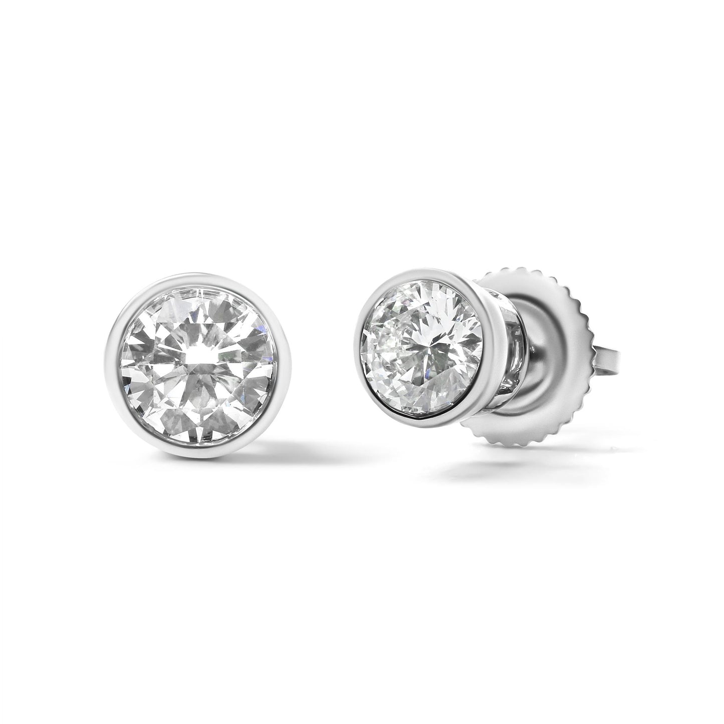 Close-up shot of a pair of white metal bezel-set round white gemstone stud earrings, shown from the front and side angles.