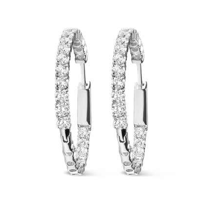 Pair of white metal hoop earrings with round white gemstones in prong settings, shown from a front angled view.