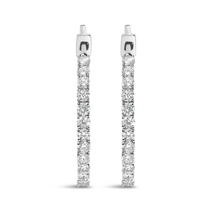 Front-facing view of white metal hoop earrings encrusted with round white gemstones in prong settings.