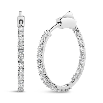 Close-up front and side view of white metal hoop earrings with round prong-set white gemstones along the outer edge.