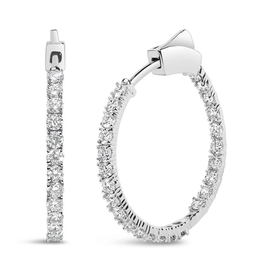 Close-up front and side view of white metal hoop earrings with round prong-set white gemstones along the outer edge.