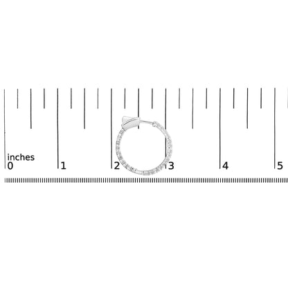 White metal hoop earring with round white gemstones in prong setting, shown from side angle on a ruler for size reference.