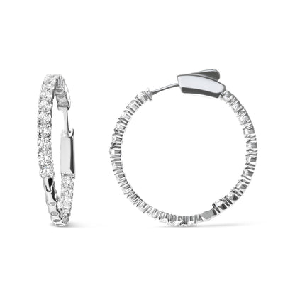 Pair of white metal hoop earrings adorned with prong-set round white gemstones, shown from front and side angles on a white background.