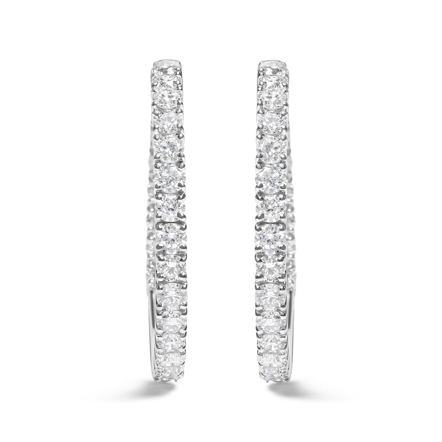 Front-facing close-up of a pair of white metal hoop earrings set with round white gemstones in prong settings.
