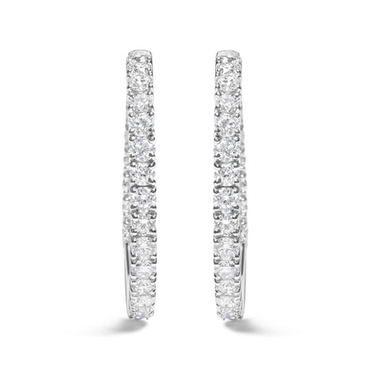 Front-facing close-up of a pair of white metal hoop earrings set with round white gemstones in prong settings.