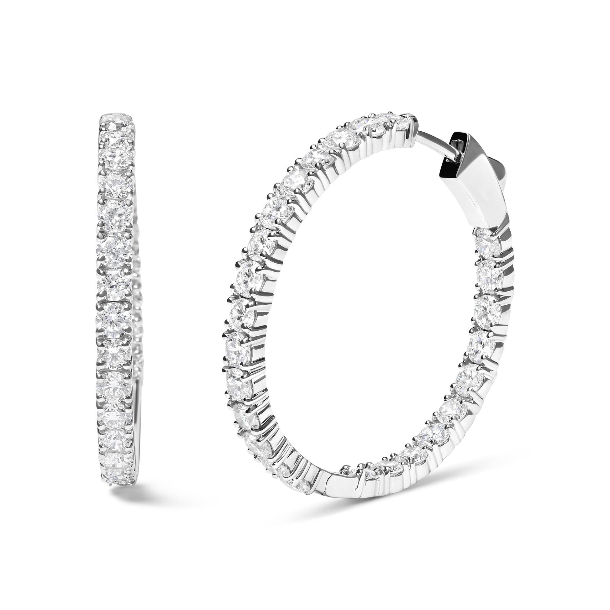 Pair of white metal hoop earrings with round white gemstones in prong settings, shown from front and side angles.