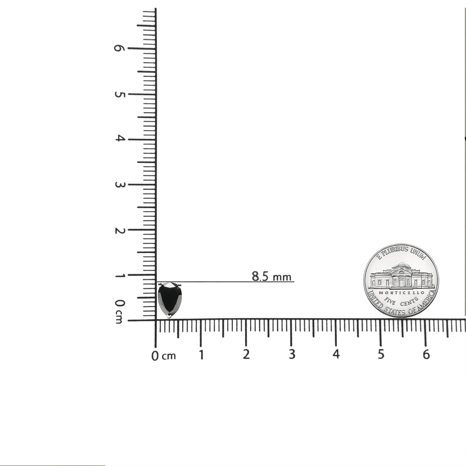 Close-up of pear-shaped black gemstone earring in prong setting on a white metal, shown on a ruler and scale for size reference.