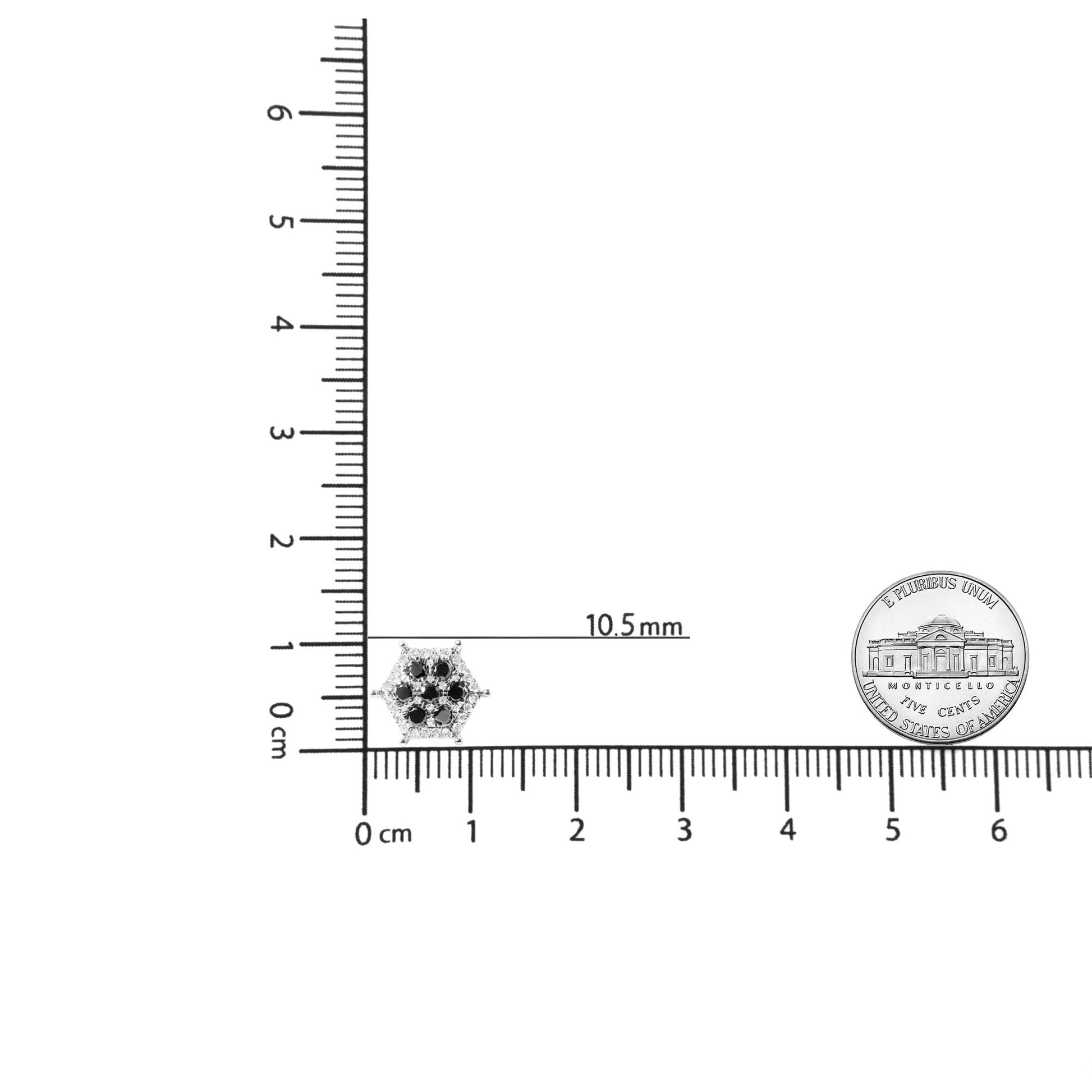 Close-up shot of a yellow metal hexagonal earring with black and white round gemstones in prong settings, placed on a ruler for size reference.