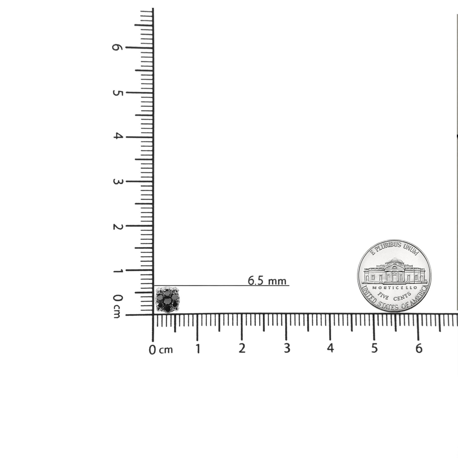 Yellow metal earrings with round black and white gemstones in prong settings, shown on a ruler for size reference from a top-down angle.