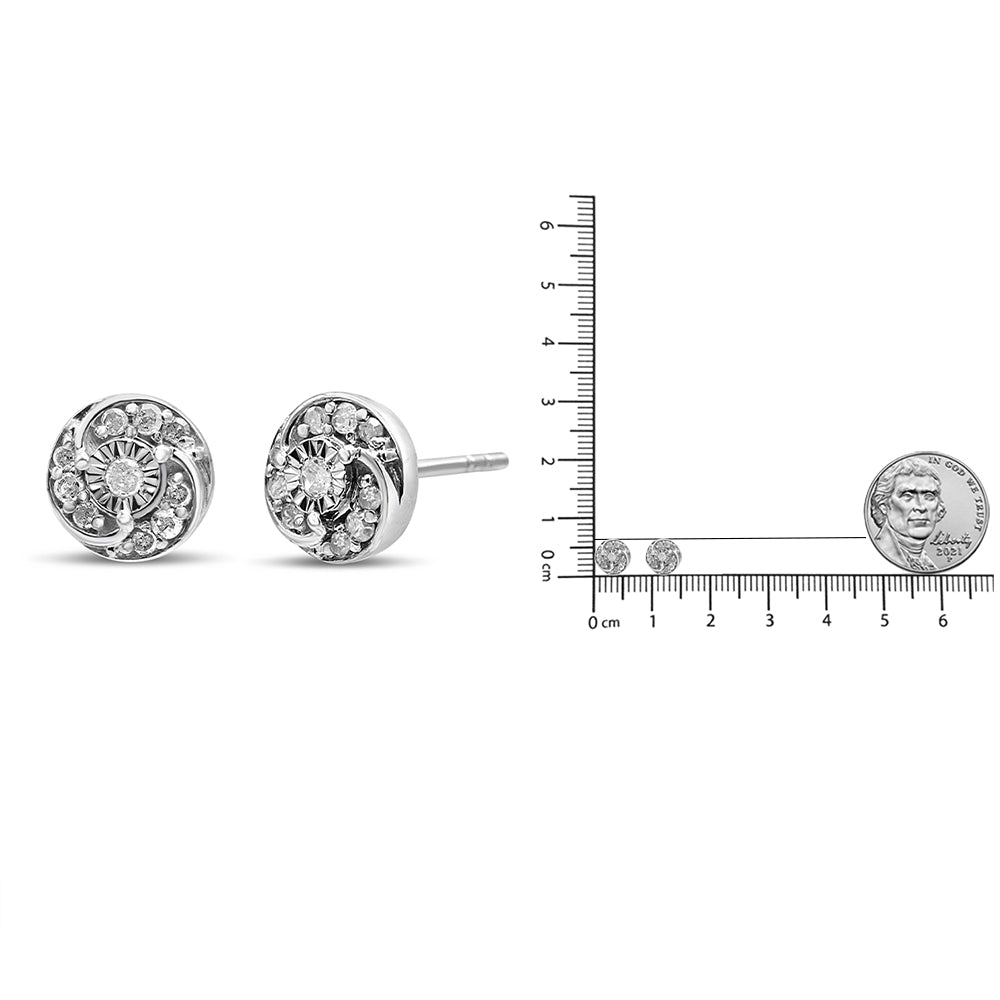 Pair of white metal round stud earrings with multiple prong set white gemstones, shown from a side angle next to a ruler and coin for size reference.