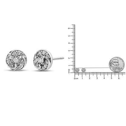 Pair of white metal round stud earrings with multiple prong set white gemstones, shown from a side angle next to a ruler and coin for size reference.