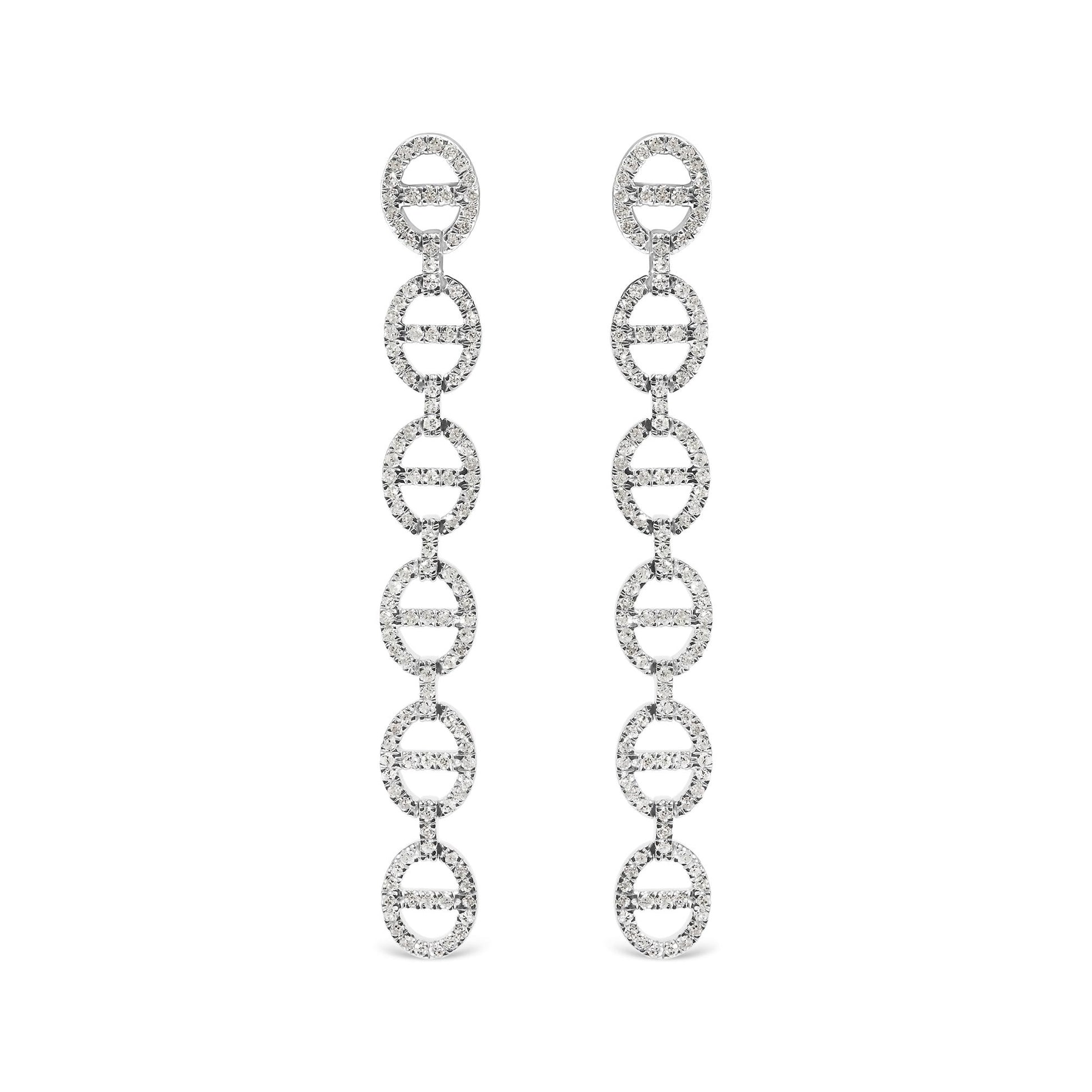 Front view of long white metal earrings composed of linked oval shapes set with round white gemstones in prong settings, shown on white background.