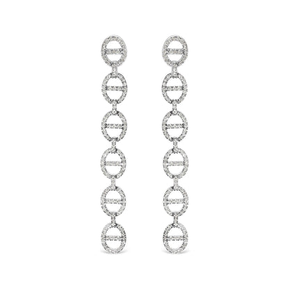 Front view of long white metal earrings composed of linked oval shapes set with round white gemstones in prong settings, shown on white background.