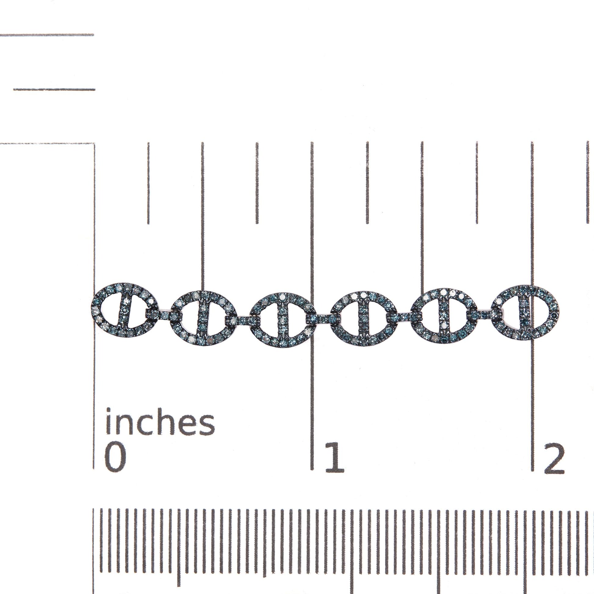Close-up front view of white metal earrings with linked circular shapes encrusted in small round blue gemstones, shown on a scale.