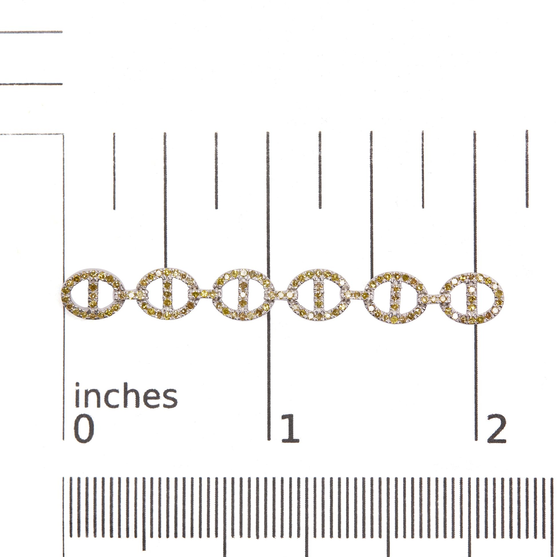Close-up front view of white metal earrings with linked circular shapes adorned with yellow and white round prong-set gemstones, shown on a scale.