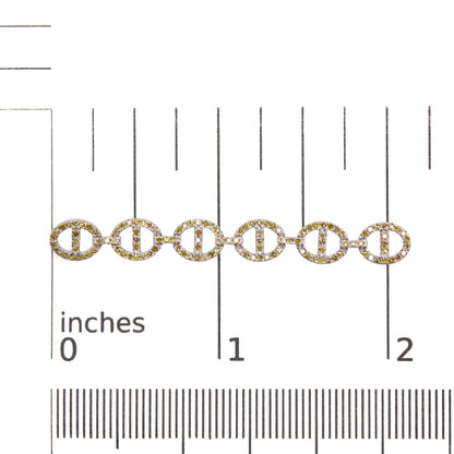 Close-up front view of white metal earrings with linked circular shapes adorned with yellow and white round prong-set gemstones, shown on a scale.