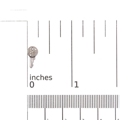 Close-up front view of one earring shown on a scale for size reference, featuring a round shape with multiple small white gemstones set in prong settings on white metal.