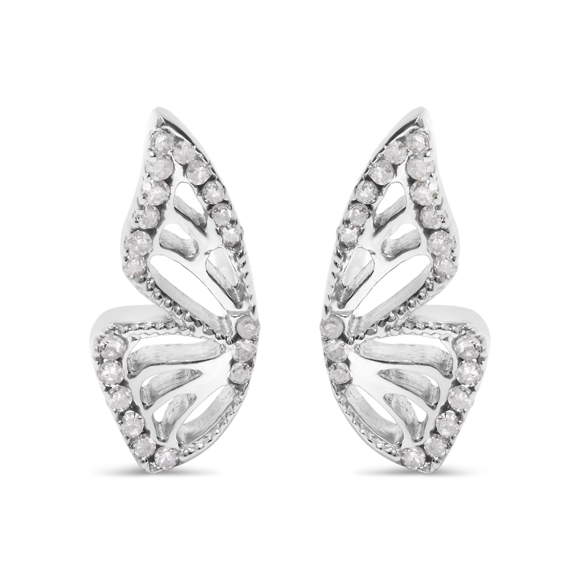 Close-up front view of a pair of white metal earrings shaped like stylized leaves, each adorned with round white gemstones in prong settings outlining the edges.
