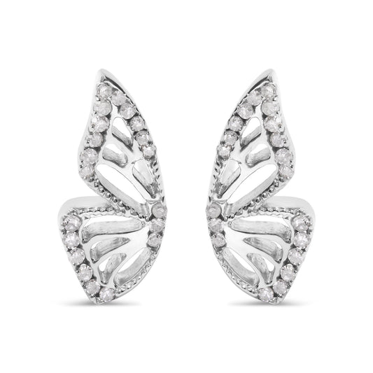 Close-up front view of a pair of white metal earrings shaped like stylized leaves, each adorned with round white gemstones in prong settings outlining the edges.