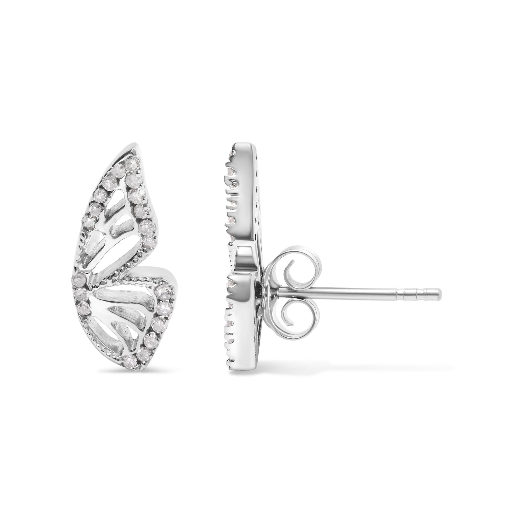 Close-up front and side view of a white metal earring shaped like an elongated leaf with open cut-out details and prong-set round white gemstones along the edges, shown on a white background.