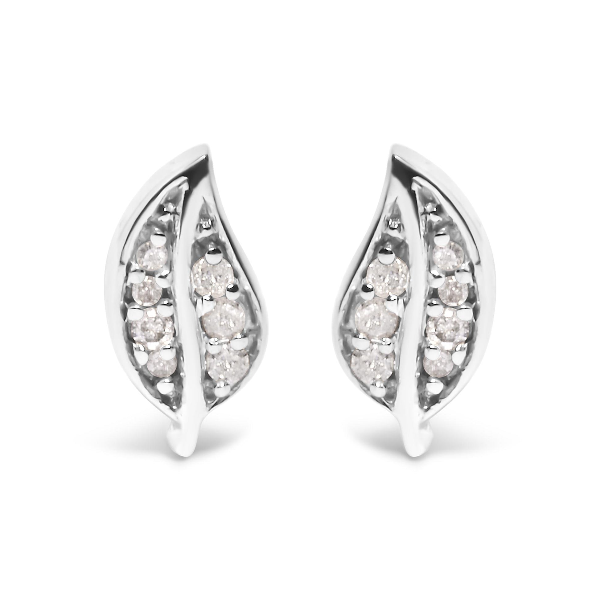 Front view of a pair of white metal earrings shaped like elongated leaves, each set with multiple round white gemstones in prong settings.