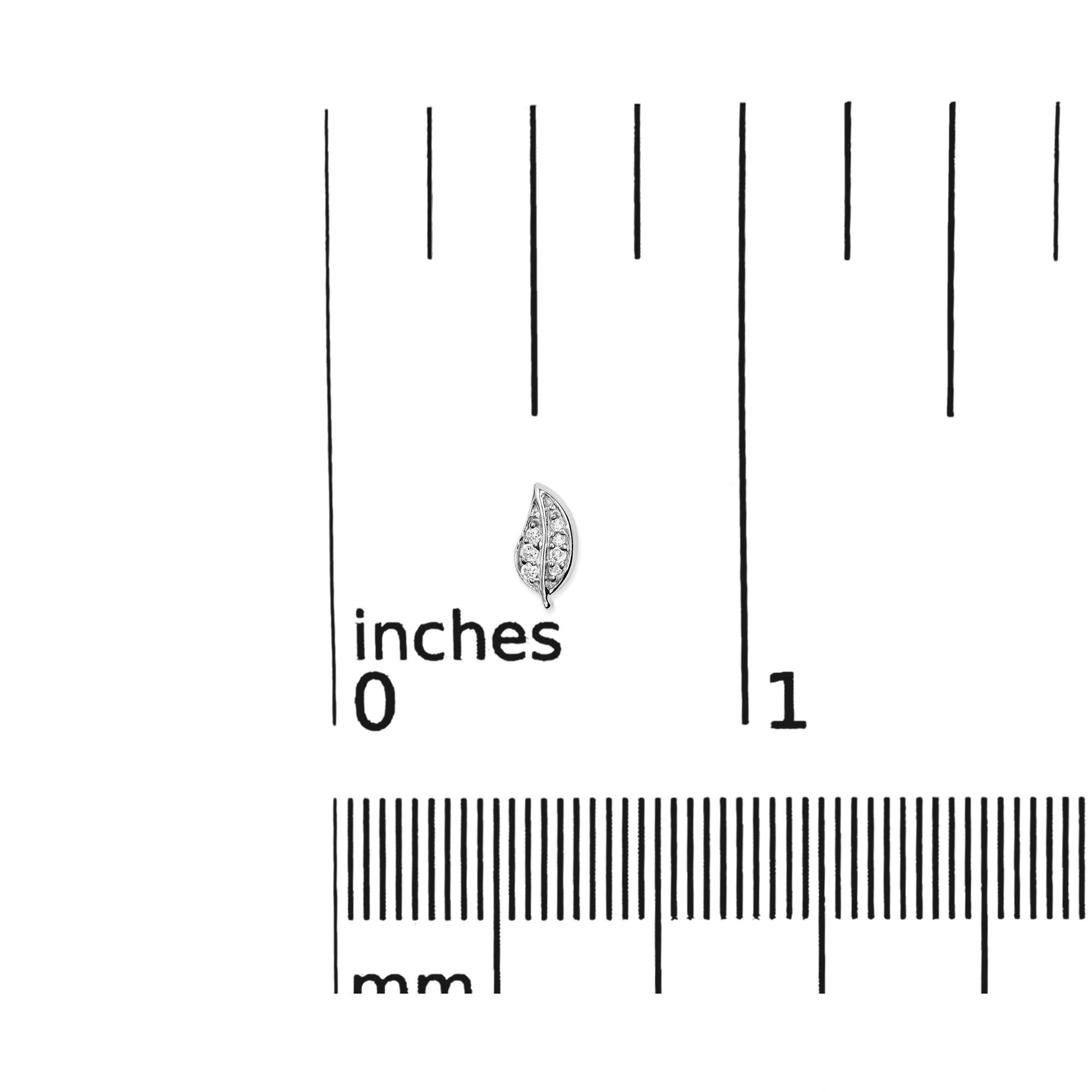 White metal leaf-shaped earring with round white gemstones in prong setting, shown on a scale from a top-down angle.