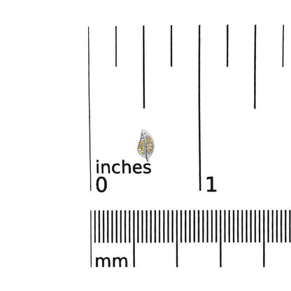 Close-up front view of a white metal leaf-shaped earring with multiple small round yellow gemstones in prong settings, placed on a ruler for size reference.