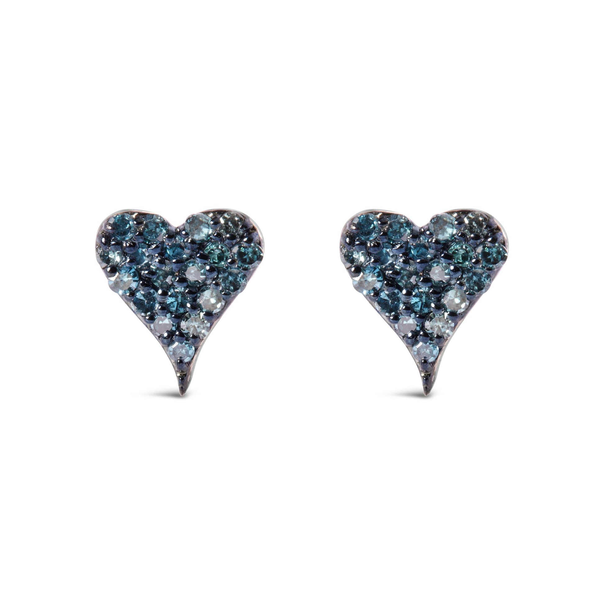 Front angle view of a pair of white metal heart-shaped earrings adorned with round prong-set blue gemstones.