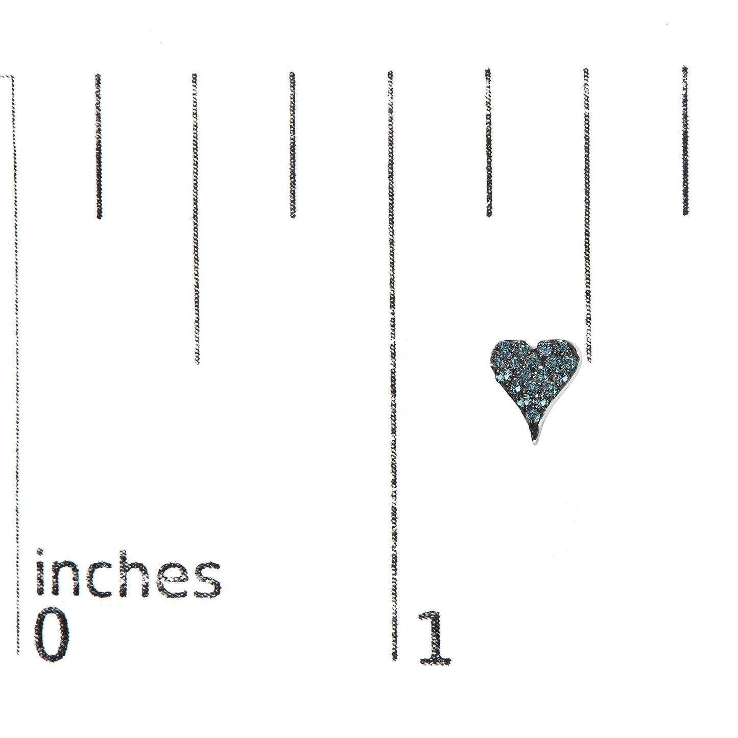 Close-up image of a white metal heart-shaped earring with round blue gemstones in prong setting, shown on a ruler for size reference.