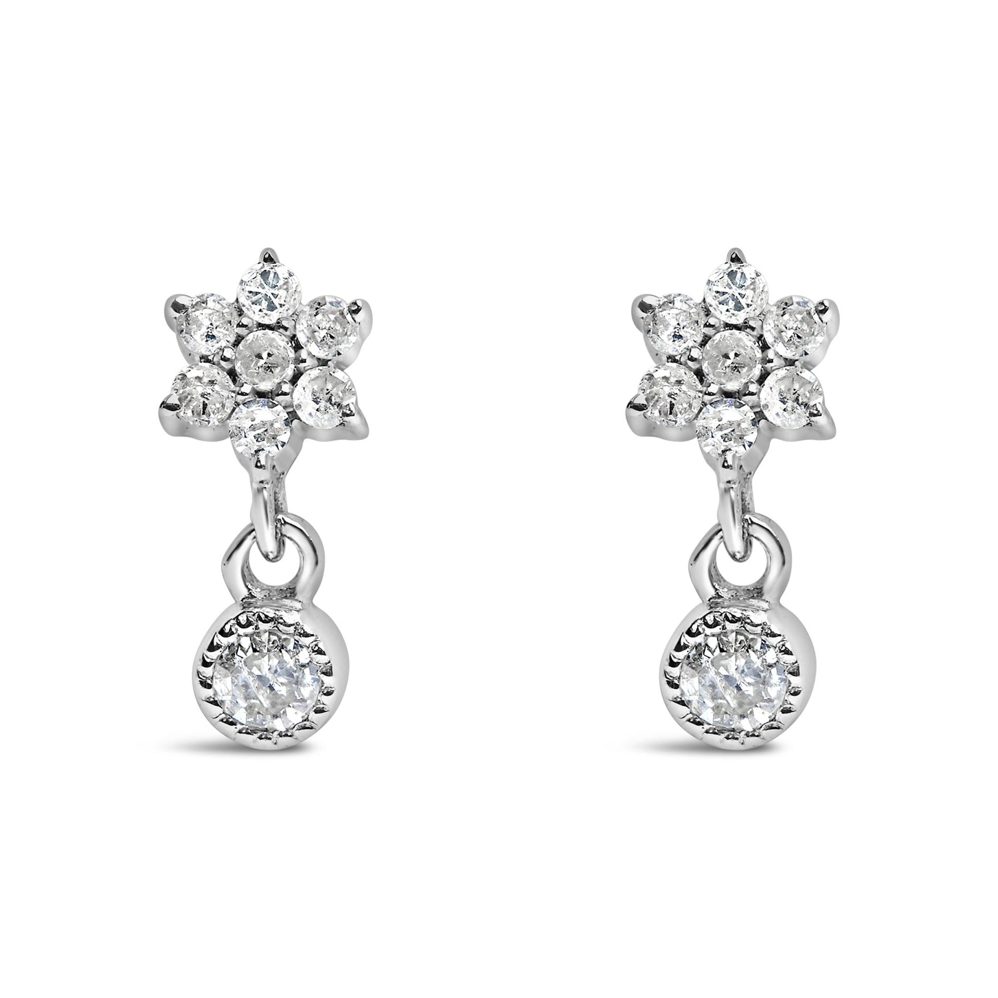 Front view of white metal earrings with round white gemstones in a prong setting, featuring a floral cluster and a single dangling gemstone.