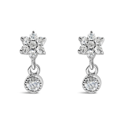 Front view of white metal earrings with round white gemstones in a prong setting, featuring a floral cluster and a single dangling gemstone.