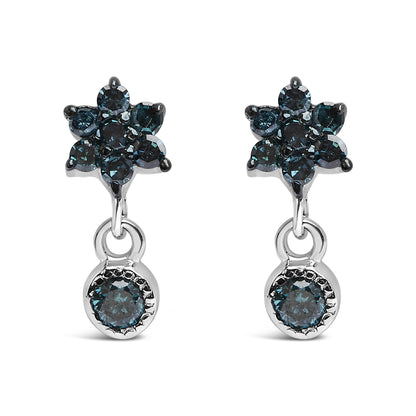 Front view of white metal earrings with blue round gemstones in prong settings forming a cluster and a single dangling blue gemstone.