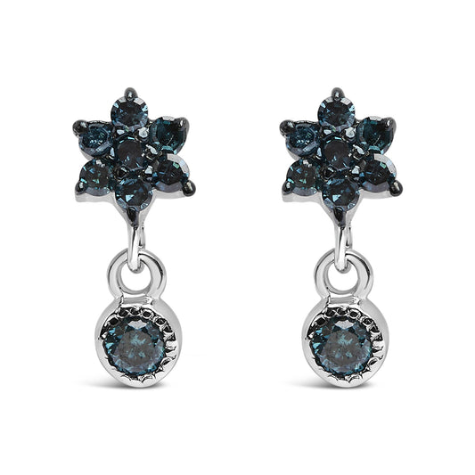 Front view of white metal earrings with blue round gemstones in prong settings forming a cluster and a single dangling blue gemstone.