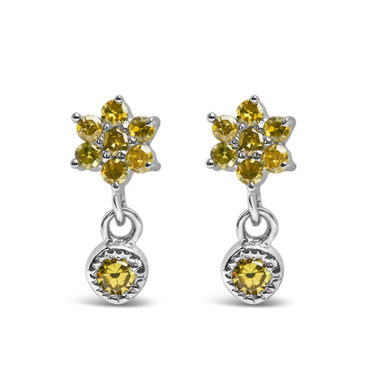 Front view of white metal earrings with cluster of yellow round gemstones at the top and a single yellow round gemstone dangle below.