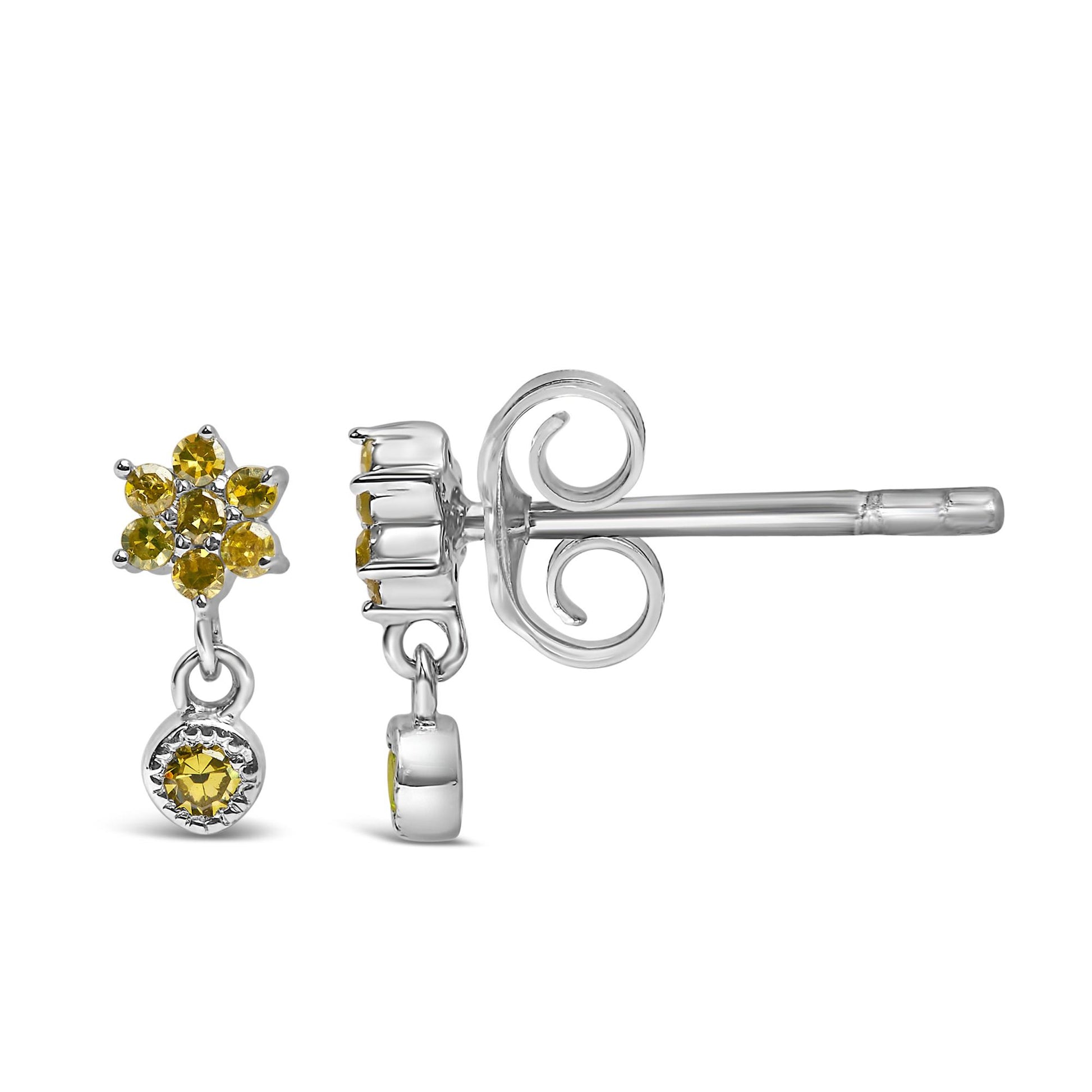 Close-up side angle of white metal earrings with round yellow gemstones in prong settings, featuring a flower-like cluster and a single dangling gemstone.