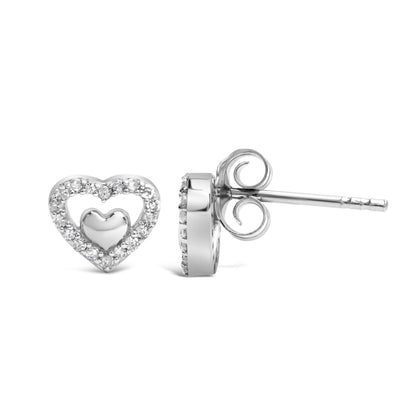 Pair of white metal heart-shaped stud earrings with round white gemstones in prong settings, shown from front and side angles.