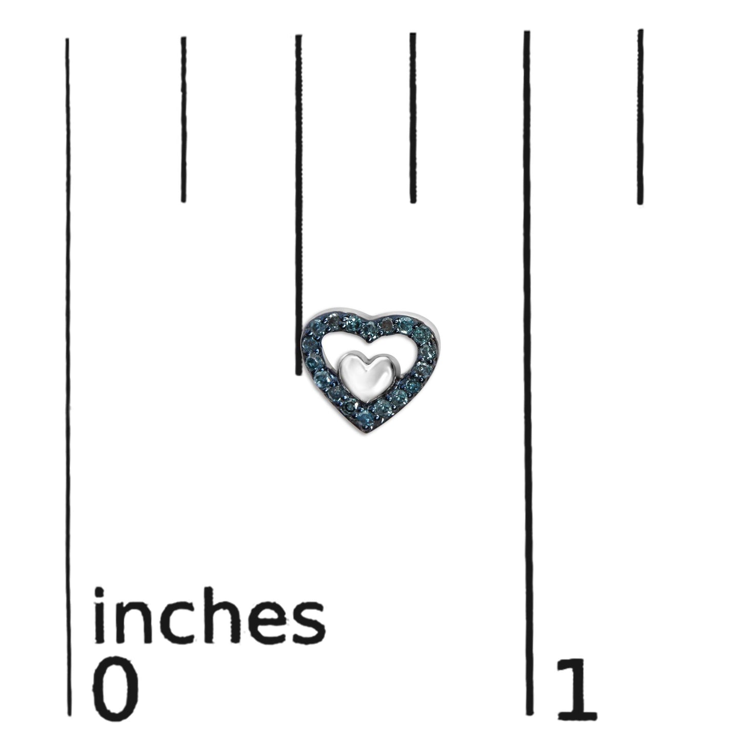 Close-up of a white heart-shaped earring with blue round prong-set gemstones, shown on a ruler for size reference.