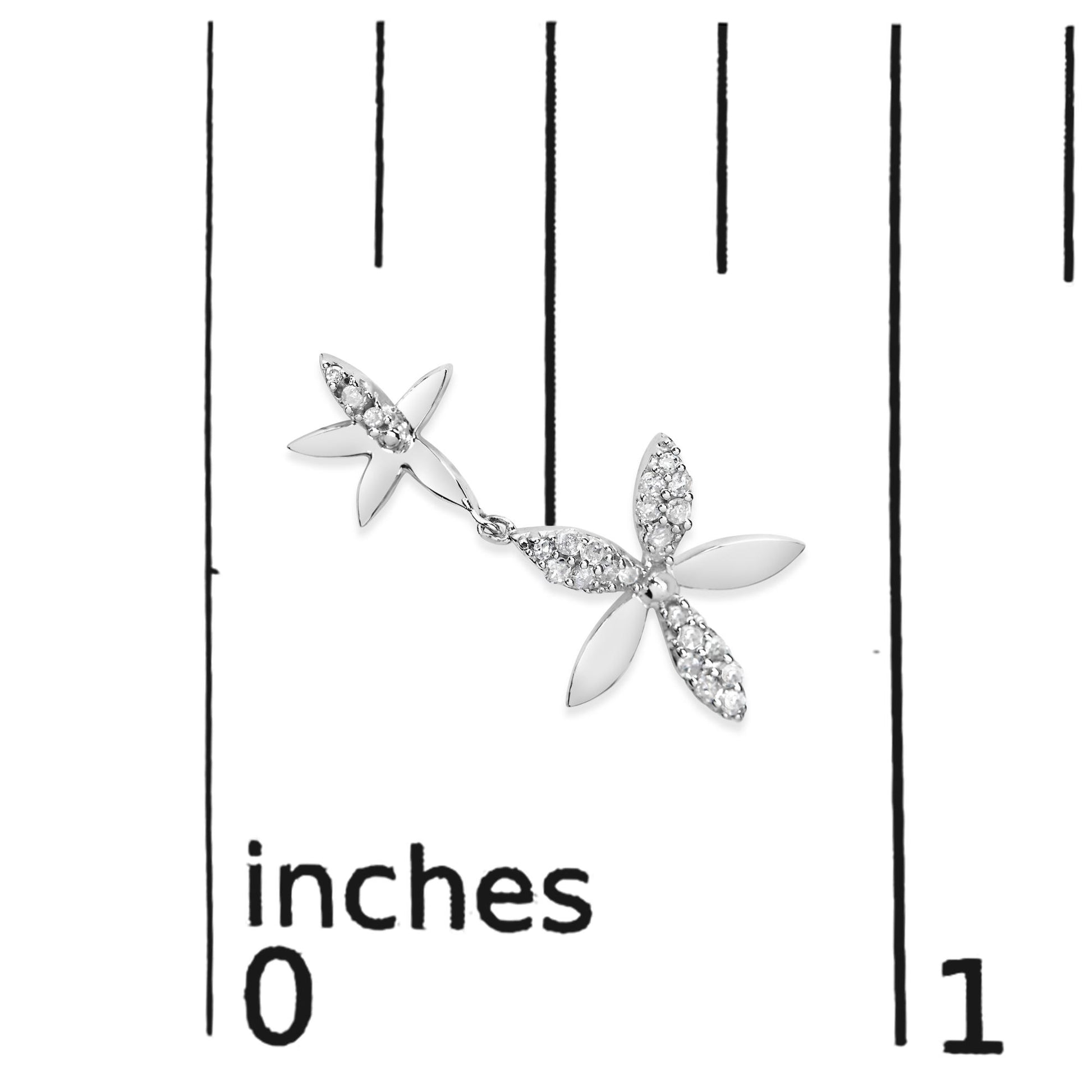 White metal earrings with floral shapes featuring round white gemstones in prong settings, shown on a scale, front angle.