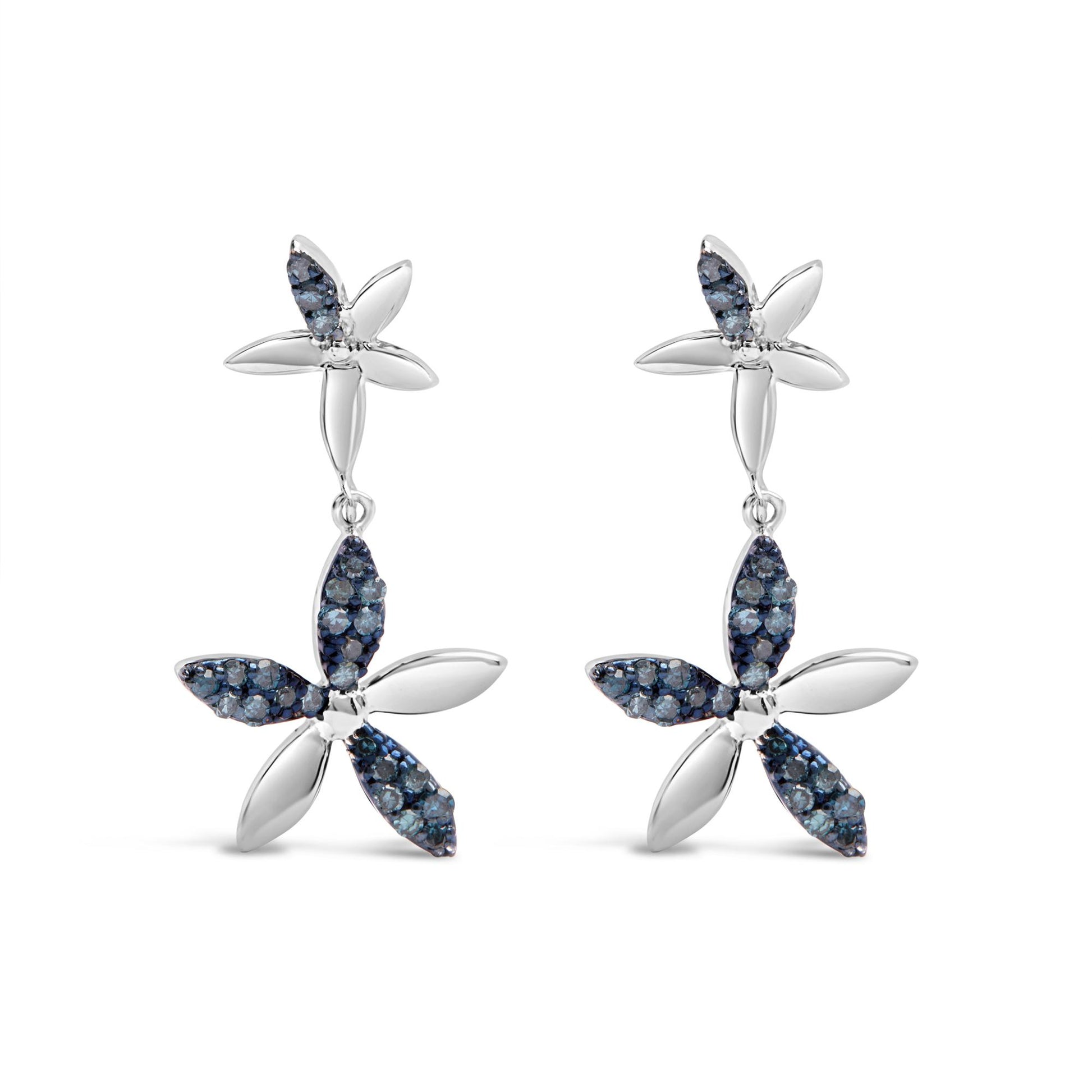 Front view of a pair of white metal earrings designed as two connected four-petal flowers, each petal partially adorned with small round blue gemstones in prong settings.