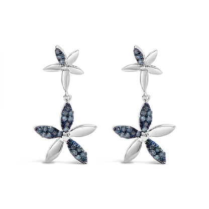 Front view of a pair of white metal earrings designed as two connected four-petal flowers, each petal partially adorned with small round blue gemstones in prong settings.