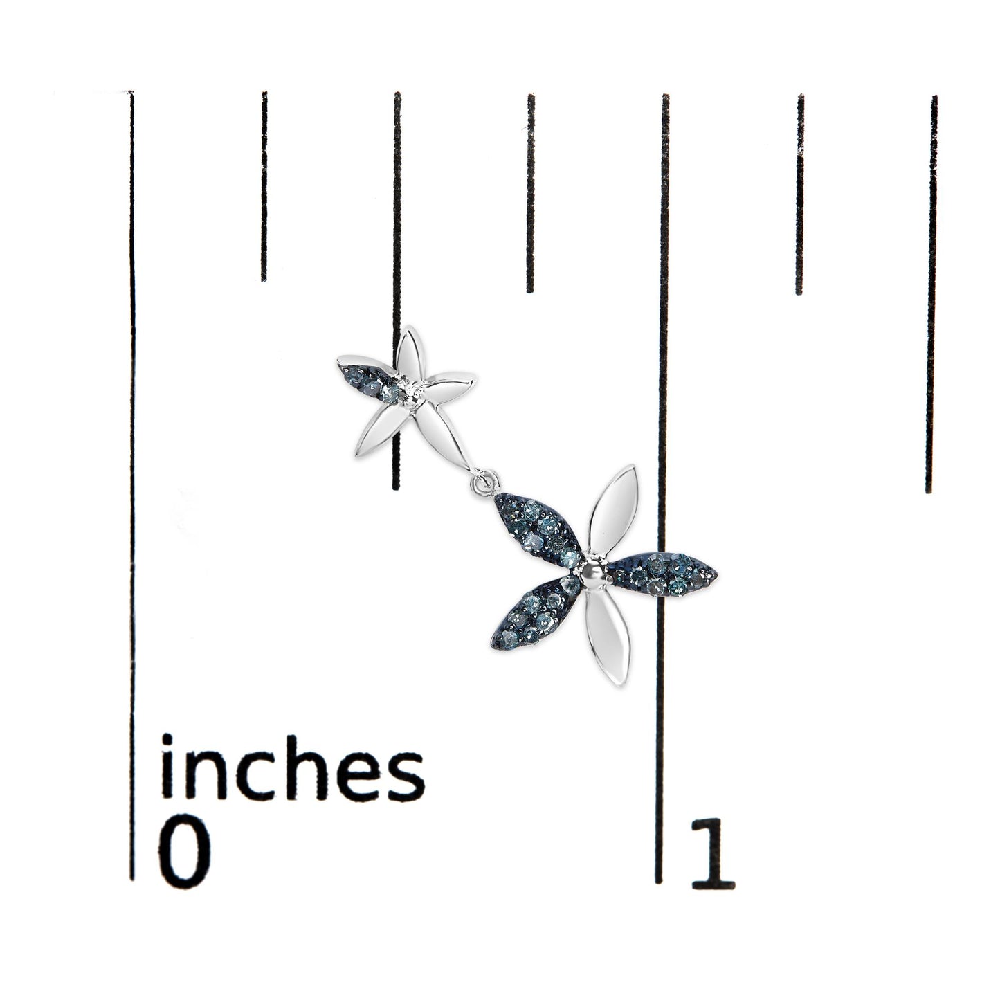 Close-up top view of a white metal dangle earring with two flower shapes, featuring round blue gemstones in a prong setting, shown on a scale.