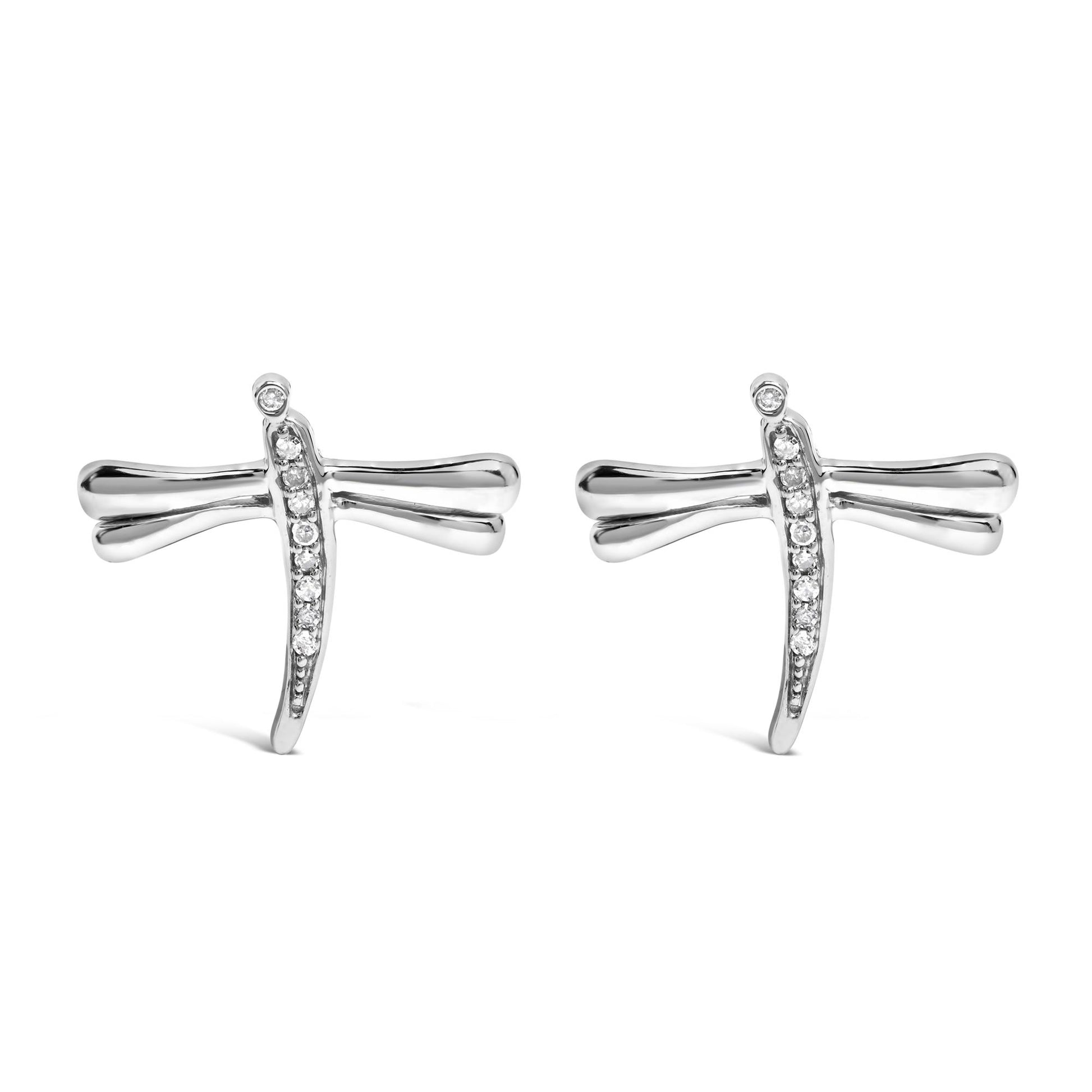 Front angle view of a pair of white metal dragonfly-shaped earrings with round white gemstones set along the vertical body and at the tip of one wing.