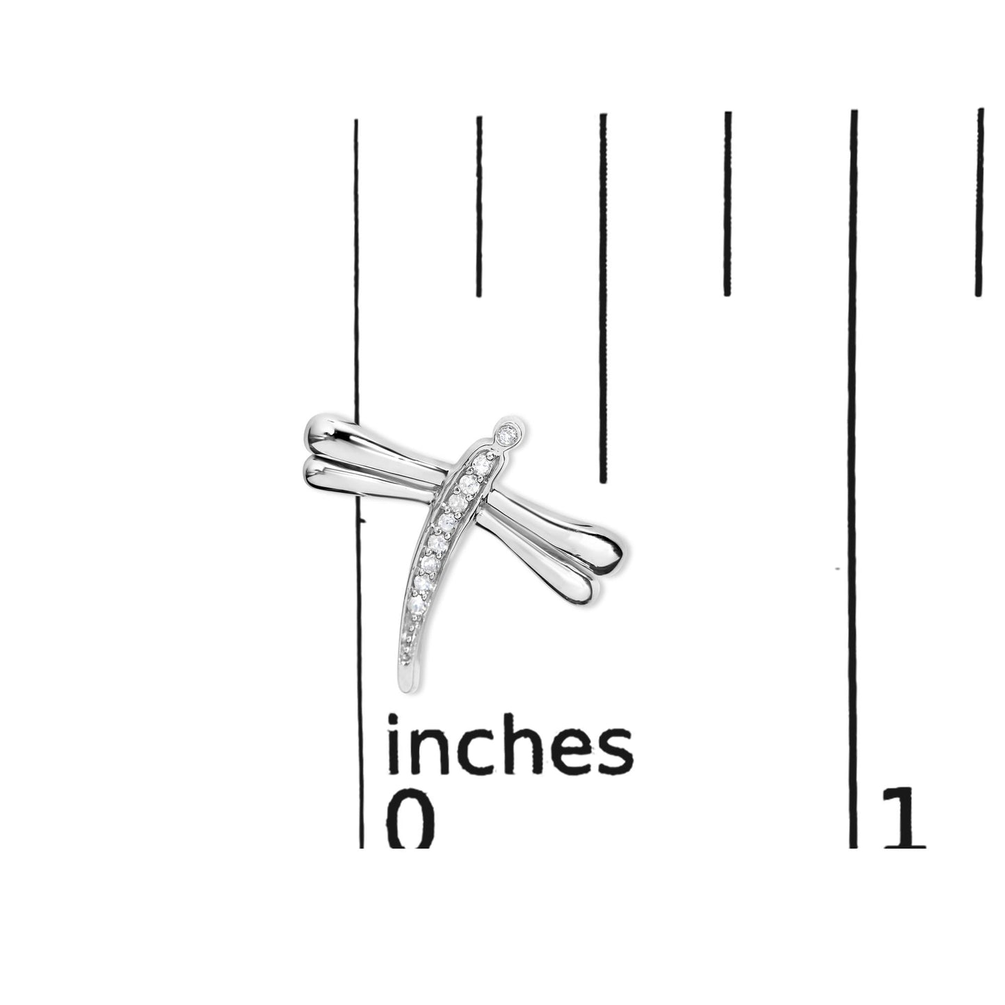 White metal dragonfly-shaped earring with round white gemstones set along the body, shown on a ruler for size reference, top-down angle.