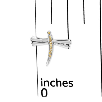 Close-up front view of a white metal dragonfly-shaped earring with prong-set round yellow gemstones, placed on a ruler for size reference.