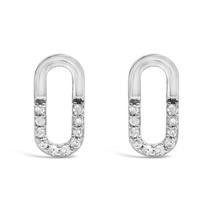 Front view of a pair of white metal oval-shaped earrings with round white gemstones set in prongs along the bottom half.