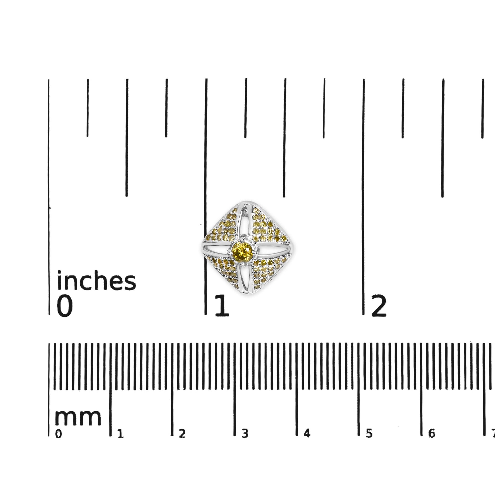 Top-down view of a white metal earring with a central round yellow gemstone and multiple smaller yellow gemstones arranged around it, placed on a ruler for size reference.